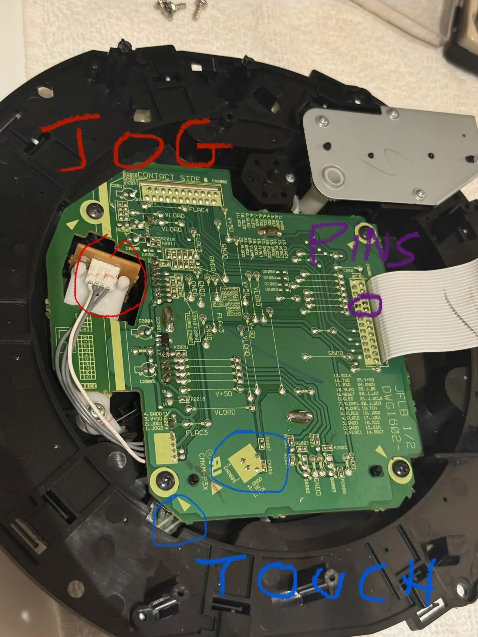 A small green circuit board on the back of the jog mechanism, with hand-drawn circles labelled JOG in red, PINS in purple and TOUCH in blue around three connectors.