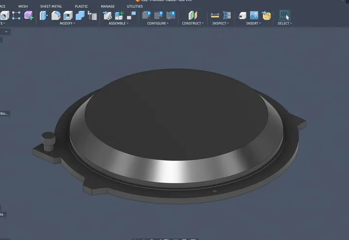 A grey 3D model of the jog wheel: a round platter on a wider base ring with mounting tabs.
