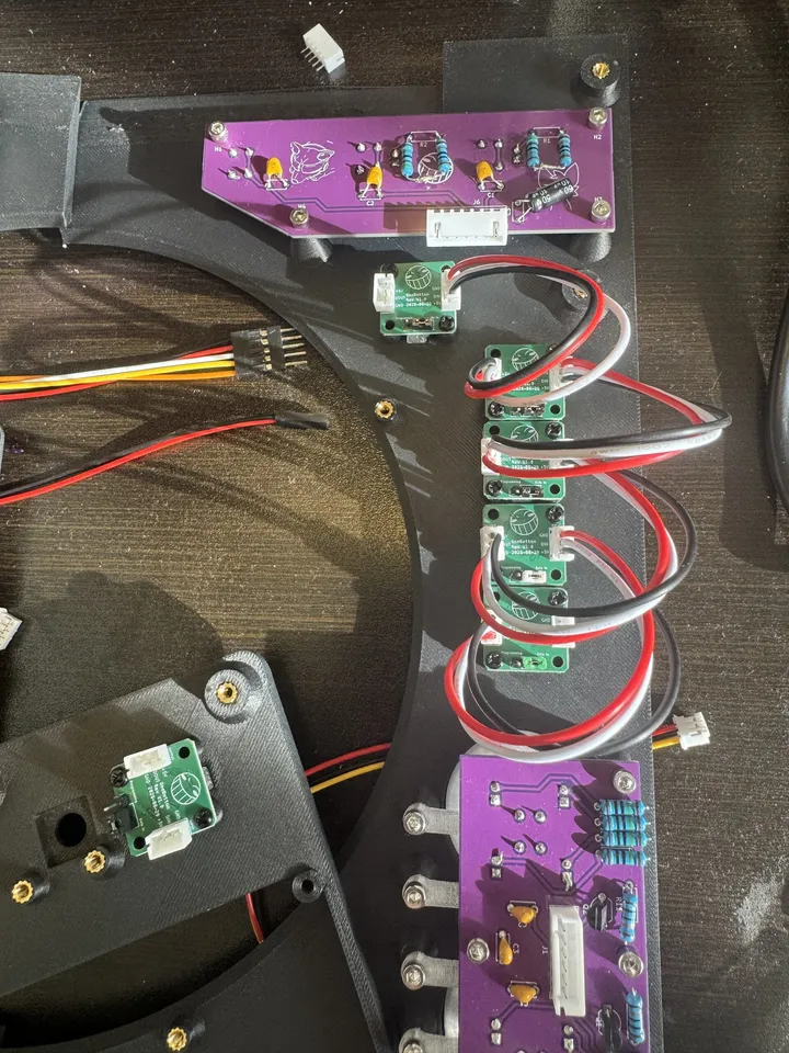Inside the printed top plate: a purple board at the top, five small square green boards chained by red, white and black wires down the middle, and a second purple board at the bottom.